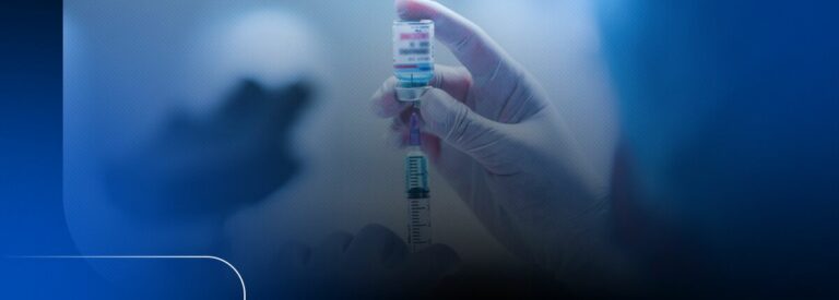 Mão segurando seringa com vacina