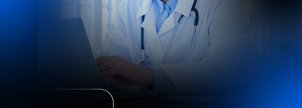 Médico utilizando um laptop em consultório.