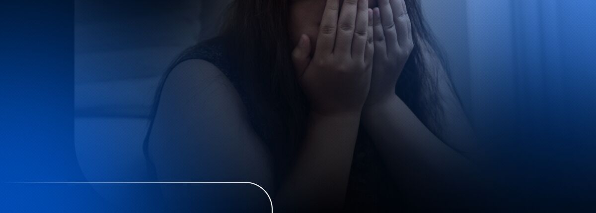 Pessoa cobrindo o rosto com as mãos em angústia