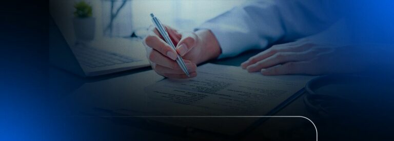 Pessoa escrevendo em um documento com laptop ao fundo