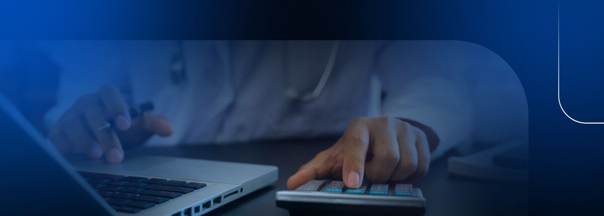 Profissional de saúde usando calculadora e laptop.