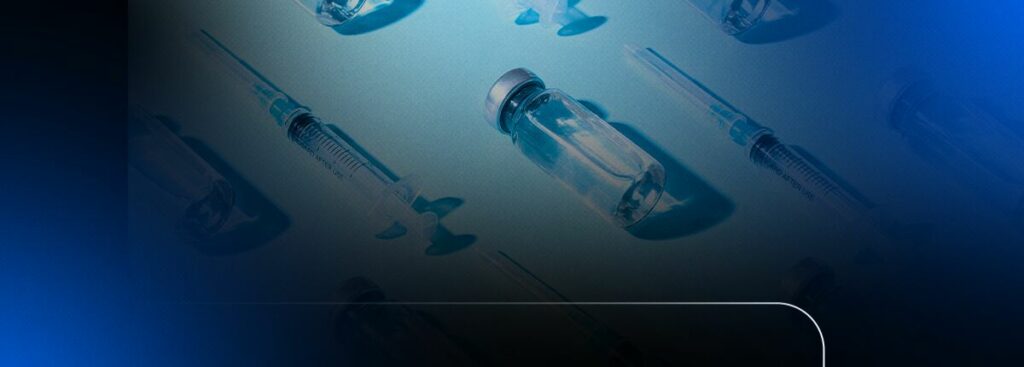 Frascos e seringas de vacinas sobre fundo azulFrascos e seringas de vacinas sobre fundo azul