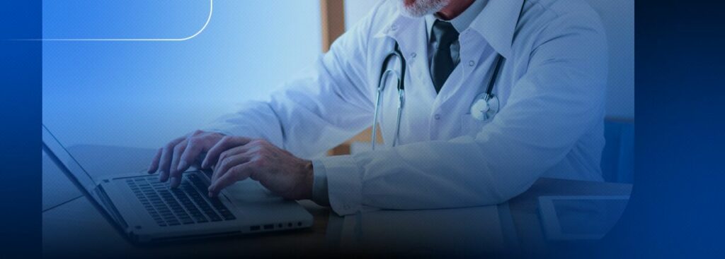 Médico usando laptop em consultório médico.