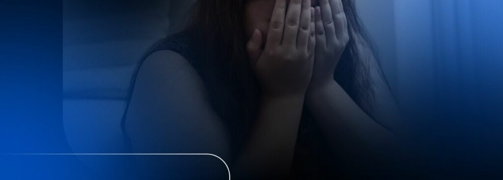 Pessoa cobrindo o rosto com as mãos em angústia