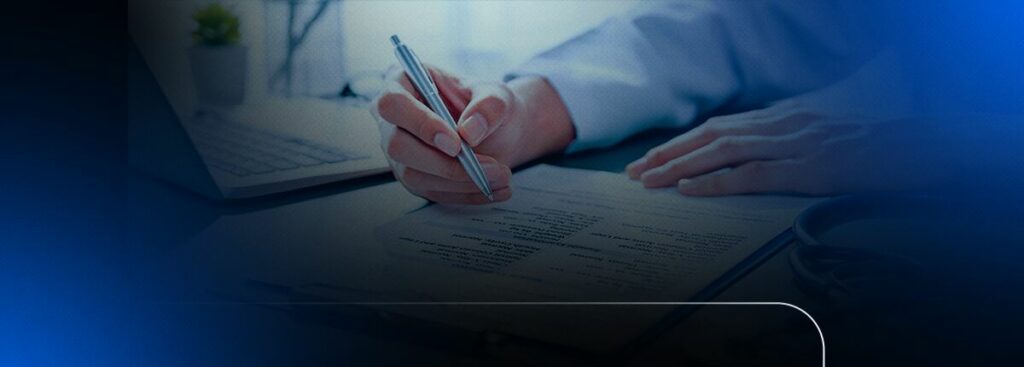 Pessoa escrevendo em um documento com laptop ao fundo