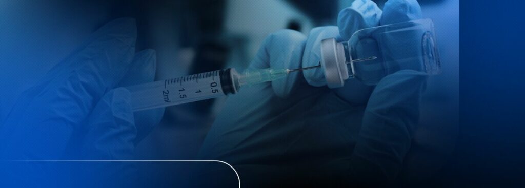 Profissional de saúde manuseando seringa e frasco