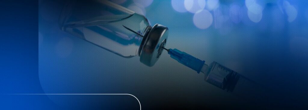 Seringa e frasco de vacina em fundo desfocado